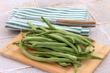 tas d'haricots verts crus sur une planche à découper