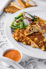 Fried omelet with slices of ham