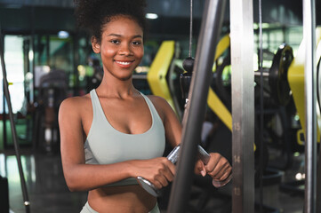 Fototapeta na wymiar African American sport woman at gym using rope for arms exercise muscular at fitness gym 