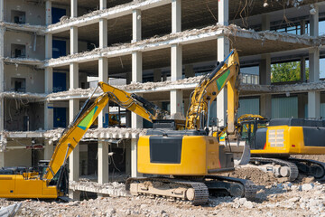 heavy duty Excavators demolishing an old commercial business house building