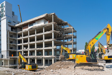 heavy duty Excavators demolishing an old commercial business house building