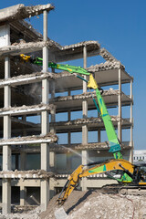 heavy duty Excavators demolishing an old commercial business house building