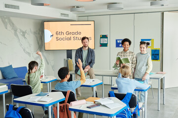 Wide angle view of school classroom with diverse group of children in 6th grade Social Studies