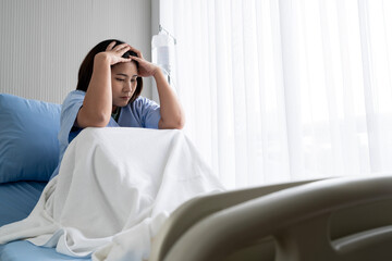 An Asian female patient was hospitalized alone in a bed by the window. with stress and sadness and loneliness