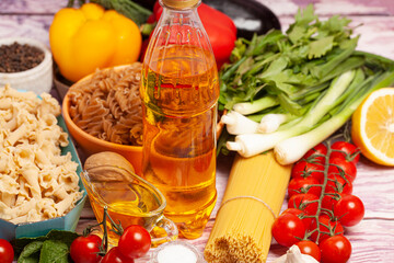 Italian pasta with vegetables, olive oil, spices on a wooden background