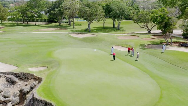 Golfer playing in golf tournament on the green putting for a birdie