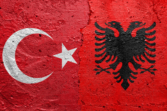 Turkey and Albania - Cracked concrete wall painted with a Turkish flag on the left and a Bosnia flag on the right stock photo