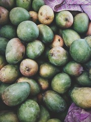green fresh mangos on the market