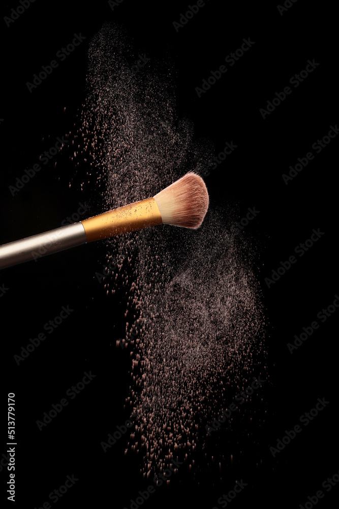 Wall mural make up brush with cosmetic powder splash, over black background. splash image