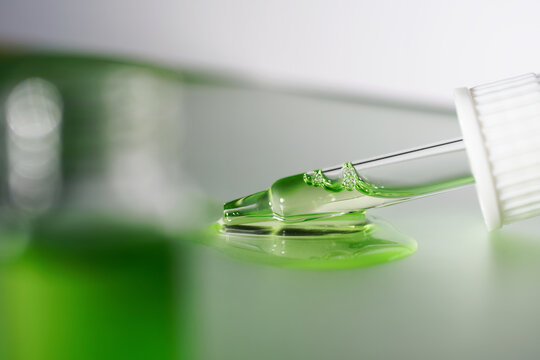 Pipette with fluid serum, oil, face gel cleaner. Cosmetics and healthcare concept closeup. Dose of retinol with air bubbles. Flat lay. Monkeypox, coronavirus research