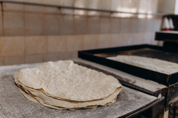 Conveyor with dough, billets for pizza.