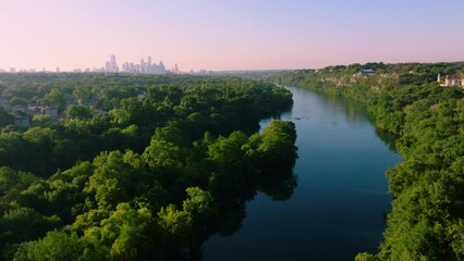 Aerial sweep of Redbud Isle nature trail in Austin, Texas during hazy summer sunrise in 2022 with 4k drone over Town Lake - Powered by Adobe
