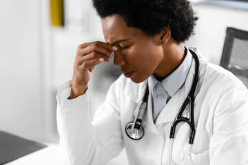 A tired and stressed female doctor at her office. Taking a break after a long shift in the clinic.