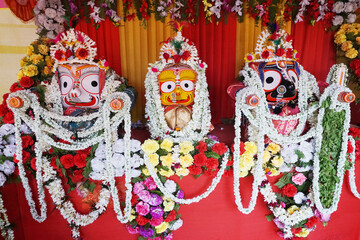 Idols of God Jagannath, Balaram and Goddess Suvadra. Lord Jagannath is being worshipped with garlands for Rath jatra festival - at Howrah, West Bengal, India.