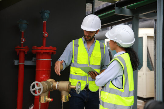 Construction project engineer check and discussing at front of fire Fighting valve or fire hydrants . new project for Fire Extinguishing system