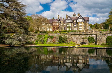 Fototapeta na wymiar Reflection in the pond and gardens of the old manor home at Bodnant Garden in North Wales in the spring