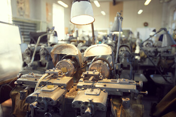 Close-up of modern lathe with metal shavings illuminated lamp, copy space