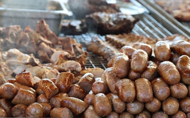 mixed meat in quantity on the grill to cook