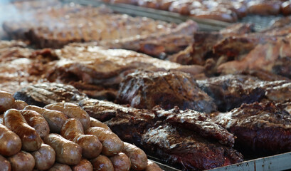 mixed meat in quantity on the grill to cook