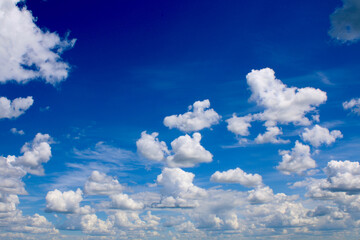 Naklejka na ściany i meble Thick white cumulus clouds in the blue sky.