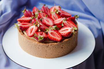 Cheesecake with strawberries on a purple background. Appetizing beautiful cake. Bright presentation