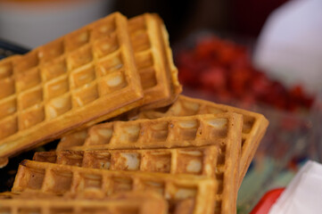 Close up of rustic traditional waffle at street food festival. Outdoor cooking service gastronomy...
