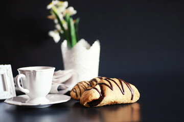 French breakfast on the table. Coffee croissant with chocolate and a decanter with cream. Fresh pastries and decaffeinated coffee.