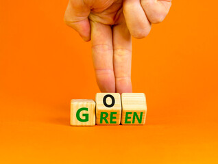 Ecology and go green symbol. Concept words Go green on wooden cubes. Businessman hand. Beautiful orange table orange background. Business ecological and go green concept. Copy space.