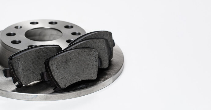 Brake disc and brake pads on a white background. Close-up, selective focus on the brake pads. copy space.