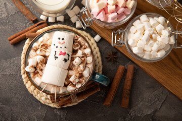 Hot chocolate mug with melted marshmallow snowman.Sweet treat for kids funny marshmallow snowman. Christmas winter holiday decoration. New Year card.Winter hot drink.