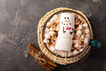 Hot chocolate mug with melted marshmallow snowman.Sweet treat for kids funny marshmallow snowman. Christmas winter holiday decoration. New Year card.Winter hot drink.