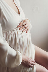 pregnant woman in white expression holding her belly