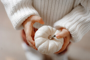 child holding a small pumpkin