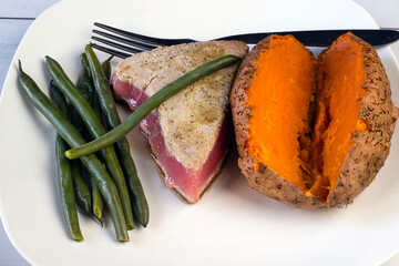 tuna steak season  with sat and pepper served with sweet potato