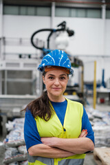 Portrait of middle-aged woman with helmet inside factory