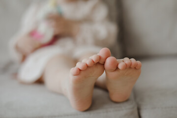 child bare little feet close-up indoors. child sitting barefoot