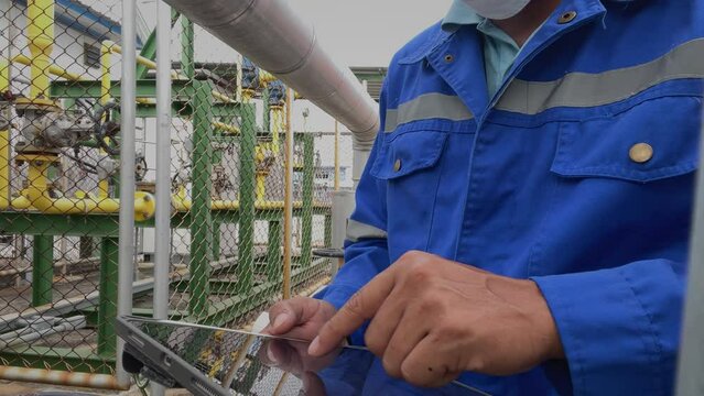 Production engineers inspect industrial equipment at pipeline at factory. Referent holding a tablet with a design sheet. Concept of industry and technology