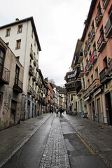 Fototapeta na wymiar Walking along the Cuesta de Gomerez in Granada during a rainy day.