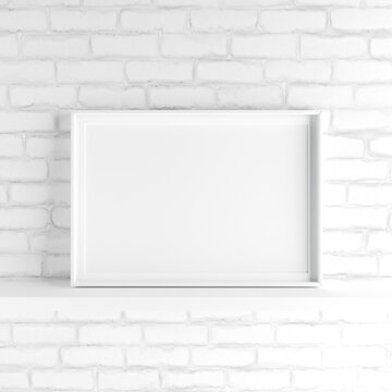 Minimalistic landscape picture frame standing on white painted brick wall