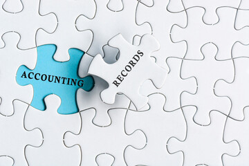 Fototapeta premium Accounting records text on blue background of white jigsaw puzzle.