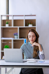 Modern Asian business woman in the home office, doing planning analyzing the financial report,...