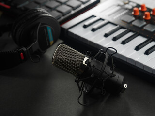 Professional musical equipment - microphone, media keyboard and headphones. New modern technologies, electronics, singing, colloquial genre, concerts, sound recording, speaker.