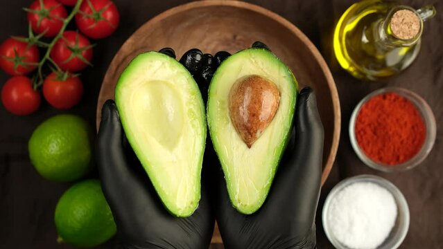 Avocado in hand. Chef peeling avocado. Cooking guacamole