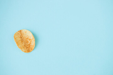 Fototapeta na wymiar top view of delicious, crunchy and salty potato chips on blue with copy space