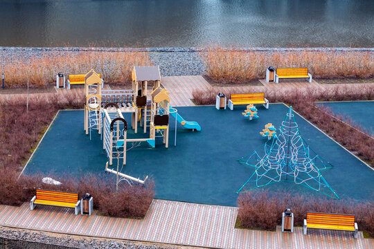 Colorful playground equipment park with sport gear dark wet rainy spring or autumn weather.