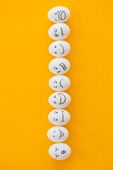 white eggs with painted smiles on yellow background. fun party.