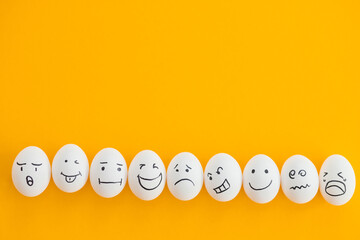 white eggs with painted smiles on yellow background. fun party.