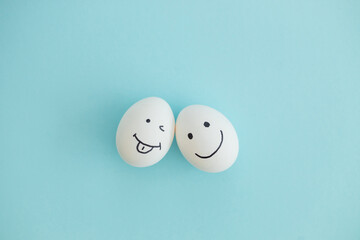 Smiling and sad eggs on a blue background