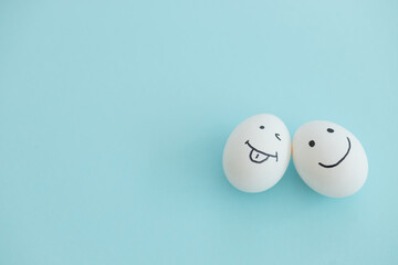 Smiling and sad eggs on a blue background