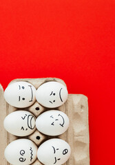 Smiling and sad eggs on a red background